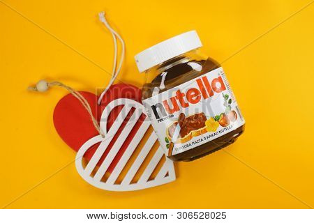Kyiv, Ukraine - May 27, 2019: Nutella introduced to the market in 1964 by Italian company Ferrero. Nutella hazelnut on yellow background