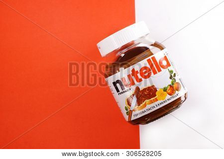 Kyiv, Ukraine - May 27, 2019: Nutella introduced to the market in 1964 by Italian company Ferrero. Nutella hazelnut on white and red background