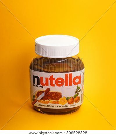 Kyiv, Ukraine - May 27, 2019: Nutella introduced to the market in 1964 by Italian company Ferrero. Nutella hazelnut on yellow background