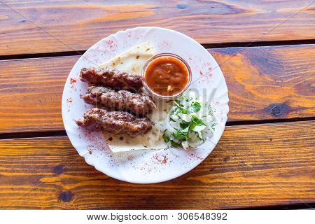 Portion Luleh Kebab On A Plate. Appetizing Dish On The Wooden Brown Table.