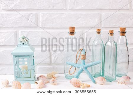 Summer Sea  Layout Near By White Brick Wall. Decorative Candle Holder With Burning Candle, Starfish 