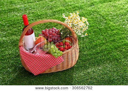 Picnic Basket With Wine And Products On Grass, Space For Text