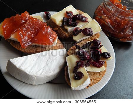 Sliced ​​camembert Cheese On Buckwheat Baguette With Dried Cranberries And Quince Confitures And A H