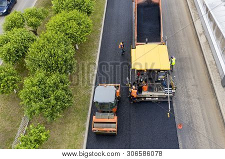 Road Works. Laying Asphalt In The City.  Shown Asphalt Paver, Asphalt Rink And Dump Truck With Aspha
