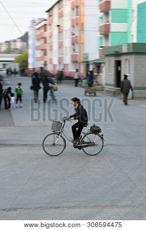 Wonsan, North Korea - May 3, 2019: Locals Girl Ride Down On The Bicycle Along A Street In The Port C