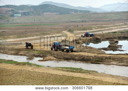 North Korea, Pyongyang - April 30, 2019: Countryside Landscape, Dprk. Peasants  Working At  Agricult