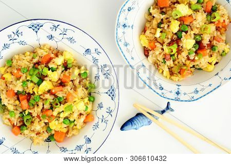 Homemade Fried Rice With Bacon, Peas, Egg, Carrot And Scallions In Pretty Blue And White Bowls With 