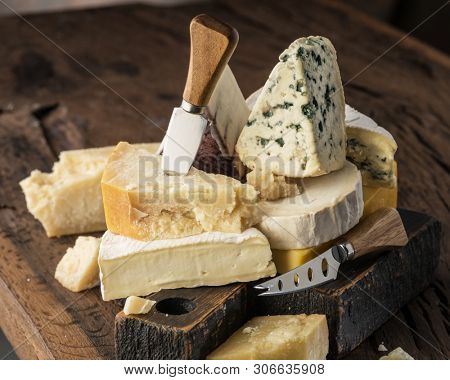 Assortment of different cheese types on wooden background. Cheese background.