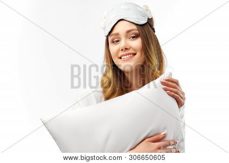 Photo Shot Of Glad Happy Woman Holds Soft White Pillow, Sleeps Well At Night, Enjoys Rest, Comfort A