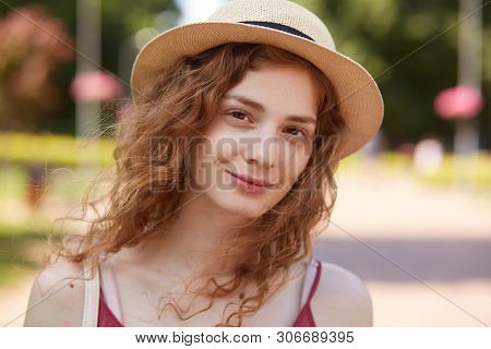 Close Up Portrait Of Charming Curly Haired Adorable Girl Having Natural Look, Being Happy To Rest At