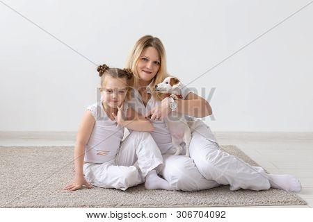 Family And Pets Concept - Mother And Child Daughter Sitting On The Floor With Puppy Jack Russell Ter