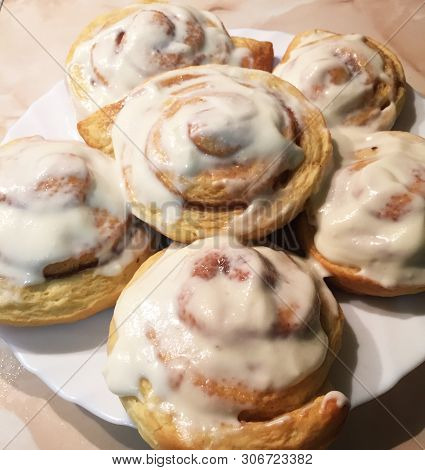 Sinnabon Buns. Cinabon Rolls With Cream Cheese On A White Plate