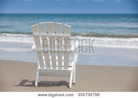 Empty White Wooden Chair At A Paradisiac Beach On The Tropics In A Beautiful Sunny Day