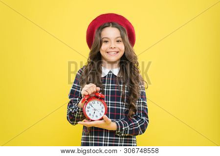 Clock Is Ticking. Small Child Smiling With Mechanical Clock On Yellow Background. Adorable Kid With 