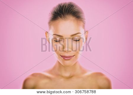 Natural Asian beauty woman model zen with closed eyes meditating calm on pink background. Young girl with slight smile pensive relaxing. Skincare clear dewy skin concept.