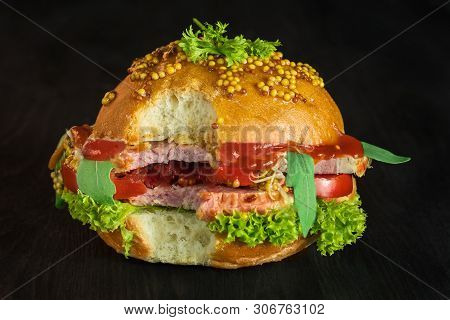 Sandwich With Pork And Fresh Vegetables And Herbs On A Dark Background