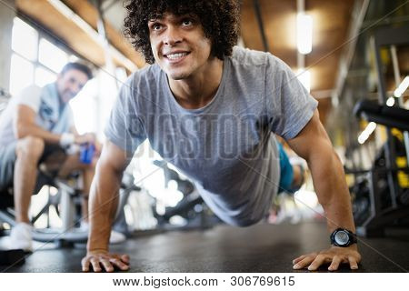 Portrait Of A Handsome Man Doing Push Ups Exercise In Gym