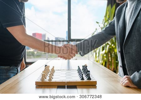 Male chess players shake hands before the game