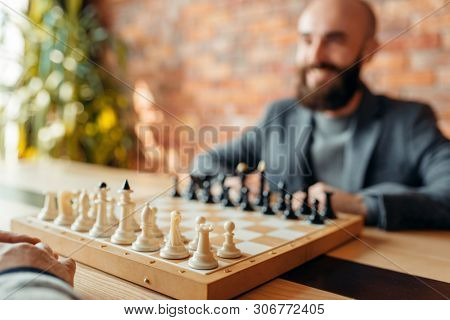 Male chess players, focus on board with figures