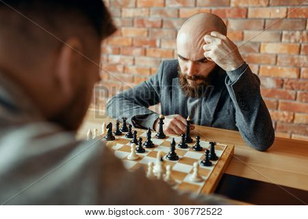 Male chess players playing, thinking process