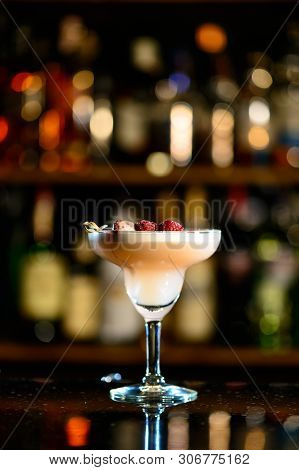 A Lifestyle Photo Of A Clover Club Alcoholic Drink In A Cocktail Glass, Standing On A Steel Barstand