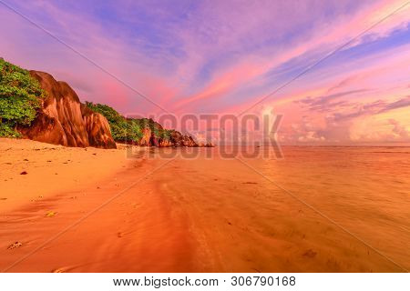 Seychelles, La Digue, Anse Source Dargent At Twilight. Landscape Of Colorful Clouds In The Sky On Ro