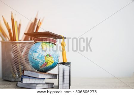 Concept Of Global Business Study Abroad Education. Graduation Hat On Models Globe, Books With Pencil
