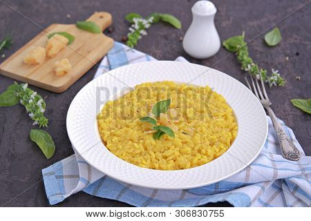 Saffron Risotto In A White Plate On A Dark Concrete Background.