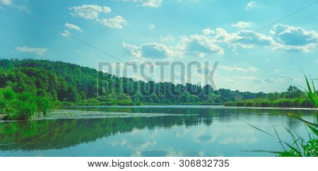 Large Lake On A Sunny Day Against The Background Of A Dense Green Forest, Nature In Russia