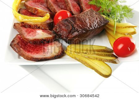 半生的牛肉肉与蔬菜在白板上