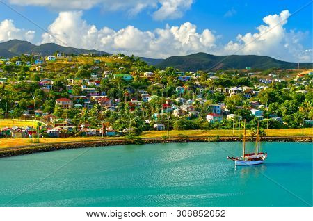Bright Image Of A Single Sailboat Moored In St John`s Harbour, Antigua With Colourful Caribbean Home