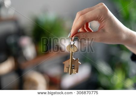 Concept Of Renting An Apartment. House Key In Womans Hands. Young Woman. Modern Light Lobby Interior