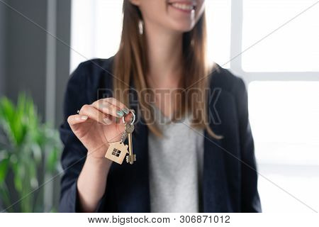 Young Pretty Woman Smiles. House Key In Womans Hands. . Modern Light Lobby Interior. Real Estate, Hy