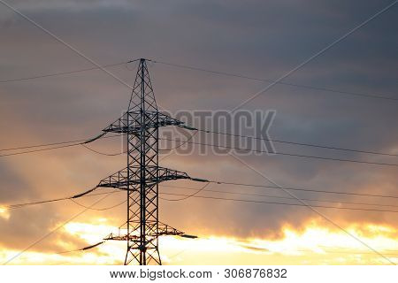 Silhouette Of High Voltage Power Line Supports With Electrical Wires On Background Of Evening Sky Wi