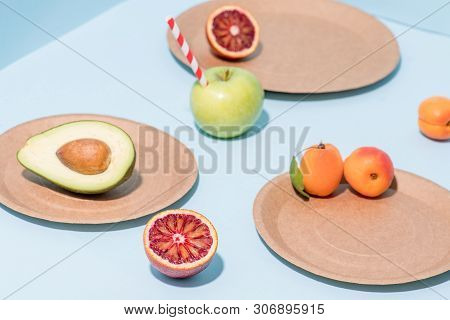 Composition Of Fresh Apricots, Cut Avocado And Blood Orange, Apple With Straw Sticking From It On Di
