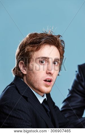 Shocked Businessman Turning To Gawp At The Camera With Open Mouth And Wide Eyes As He Sits In A Meet
