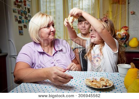Kirov, Russia - November 04, 2018: Adalt Mother And Her Young Daughter In A Kitchen With Pancakes