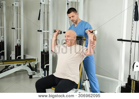 Patient Exercising Under Physiotherapist Supervision In Rehabilitation Center