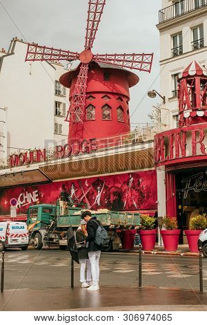 Paris, France - April 9, 2019: Moulin Rouge Building With The Red Windmill On Its Roof Cabaret In Pa