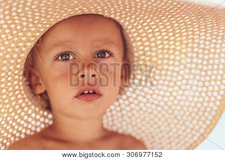 Cute Boy In A Straw Hat On The Beach