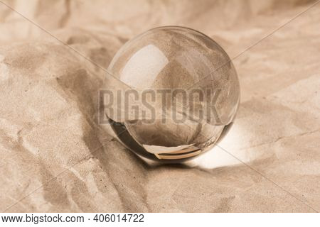 Crystal, Transparent Ball, Sphere On  Crumpled Paper Background.