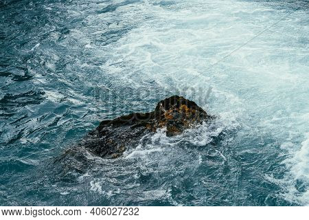 Mossy Stone In Azure Water Of Mountain River Close-up. Blue Nature Background With Boulder With Moss