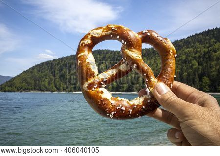 Hand Holding A Pretzel At Walchensee In Bayern