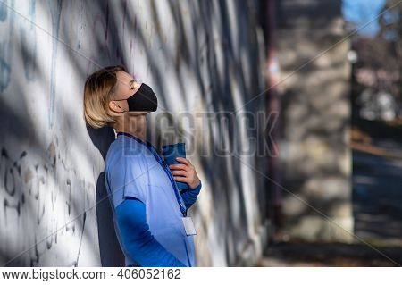 Tired Woman Caregiver Or Healthcare Worker Having A Break Outdoors, Coronavirus Concept.