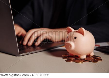 Businessman Is Working At Office, Piggy Bank With Coins At Desk