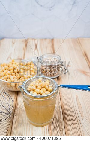 On A Light Wooden Background, A Decoction Of Aquafaba Chickpeas. Aquafaba Is A Source Of Vegetable P