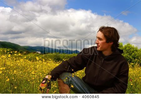 Jovem no Prado amarelo em tempo ensolarado