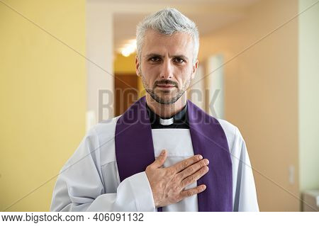 Priest Cleric Praying With His Hand On Heart