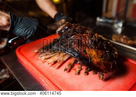 Chev Cuts Juicy Cooked Meat, Separating The Meat From The Bone With A Knife.
