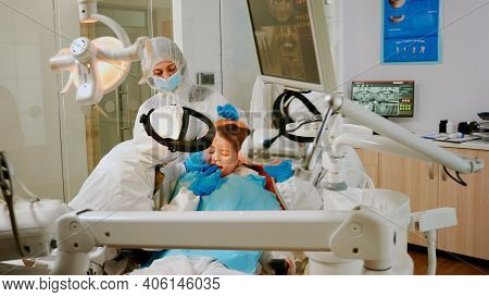 Child On Dental Chair In Dentist Surgery Treated With Dental Drill During Covid-19 Pandemic. Orthodo
